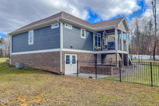 view of side of home with a yard, central AC, french doors, and a balcony