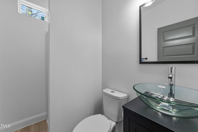 bathroom with hardwood / wood-style flooring, vanity, and toilet