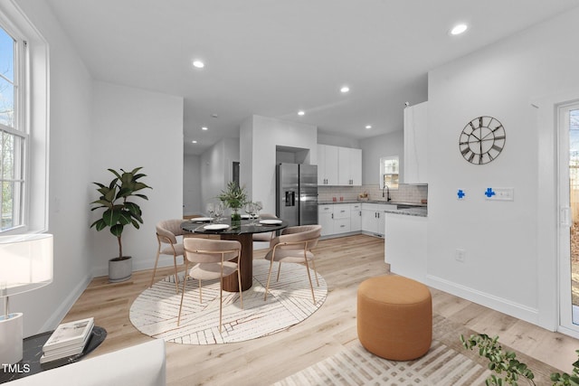 dining space with sink and light hardwood / wood-style flooring