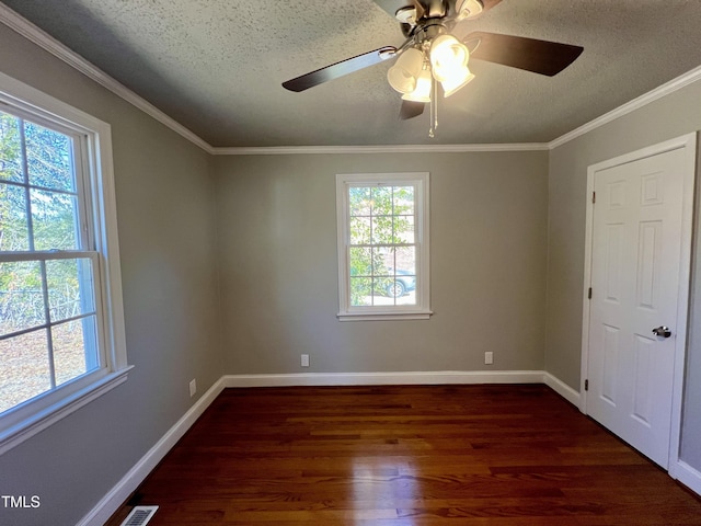 spare room featuring dark wood-type flooring, crown molding, and a textured ceiling