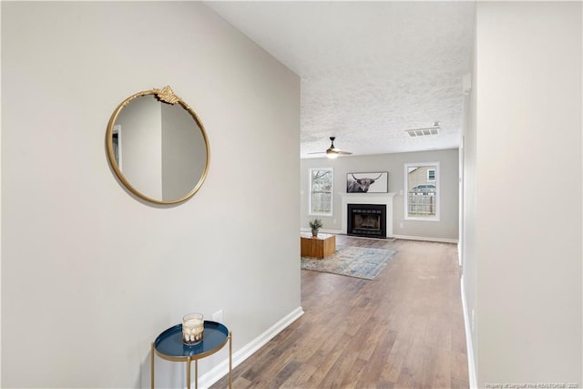 corridor with hardwood / wood-style flooring and a textured ceiling