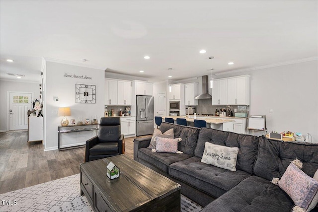 living room with recessed lighting, baseboards, wood finished floors, and crown molding