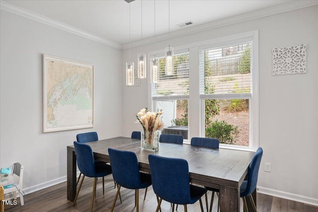 dining space featuring visible vents, baseboards, dark wood finished floors, and crown molding