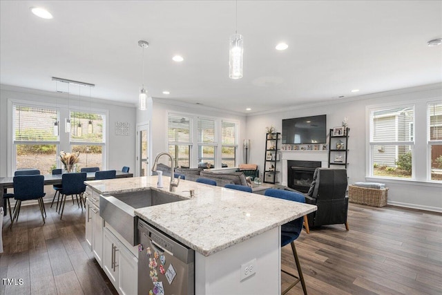 kitchen with a sink, dark wood-type flooring, white cabinets, stainless steel dishwasher, and crown molding