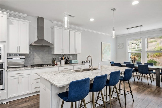 kitchen with decorative backsplash, dark wood-style flooring, wall chimney exhaust hood, and ornamental molding