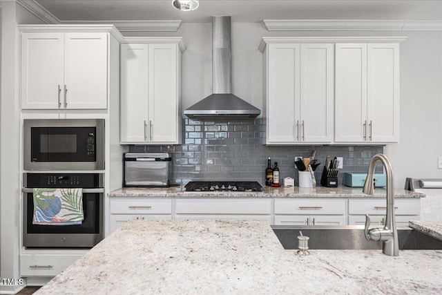 kitchen featuring tasteful backsplash, built in microwave, stainless steel oven, wall chimney exhaust hood, and gas cooktop