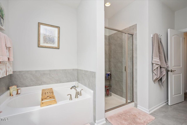 bathroom with tile patterned flooring, a garden tub, baseboards, and a stall shower