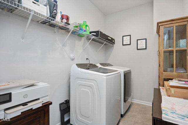 clothes washing area featuring baseboards, independent washer and dryer, and laundry area