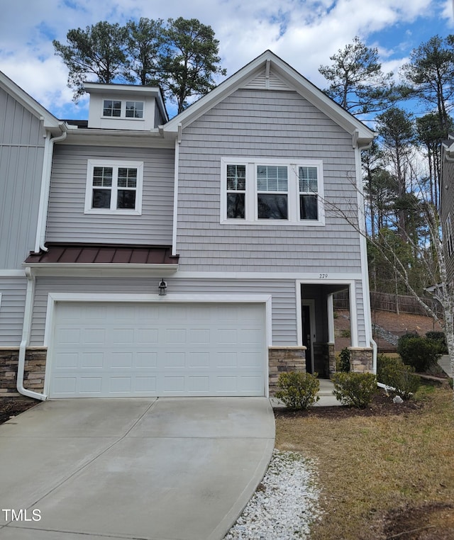 view of front facade with driveway, a standing seam roof, stone siding, metal roof, and a garage