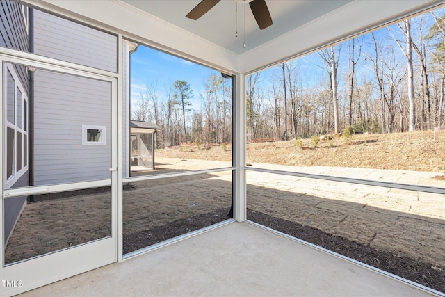 unfurnished sunroom with ceiling fan