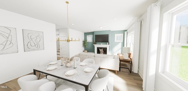 dining area featuring plenty of natural light, a fireplace, and light wood-style flooring