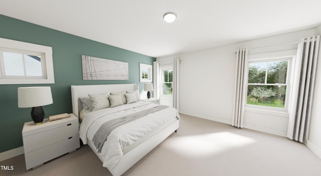 bedroom with light colored carpet and baseboards