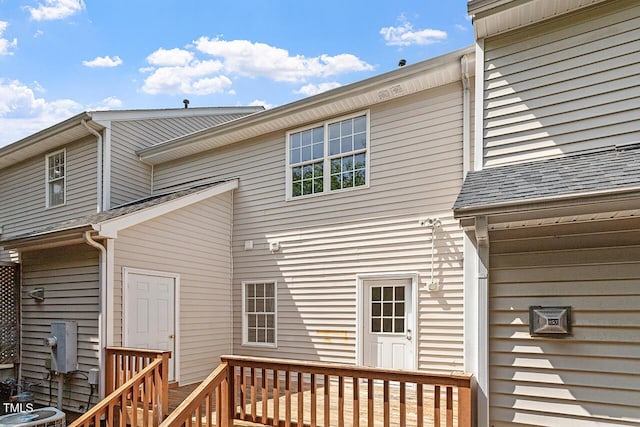 rear view of house with cooling unit and a deck