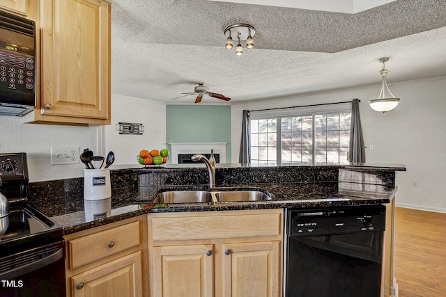 kitchen featuring sink, dark stone countertops, hanging light fixtures, black appliances, and light brown cabinets