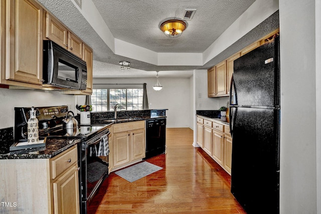 kitchen featuring sink, wood-type flooring, black appliances, a textured ceiling, and light brown cabinets