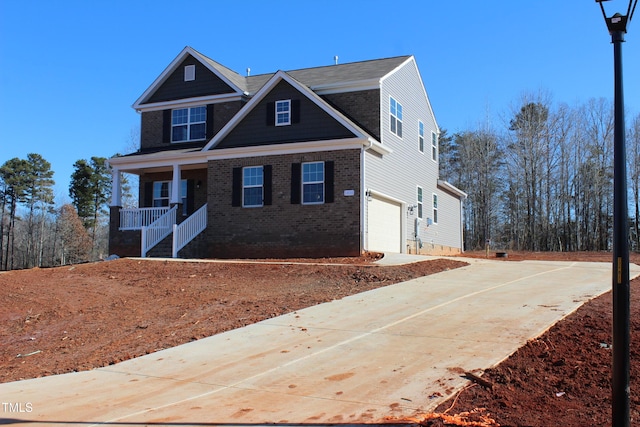 craftsman inspired home with a garage and covered porch