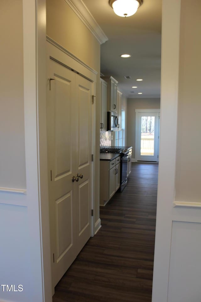 corridor featuring ornamental molding and dark wood-type flooring