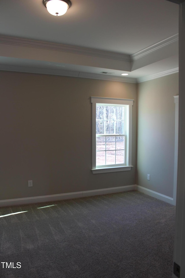 spare room with dark carpet, a tray ceiling, and crown molding