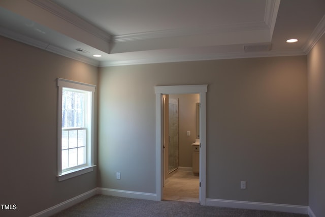 carpeted empty room with ornamental molding and a tray ceiling