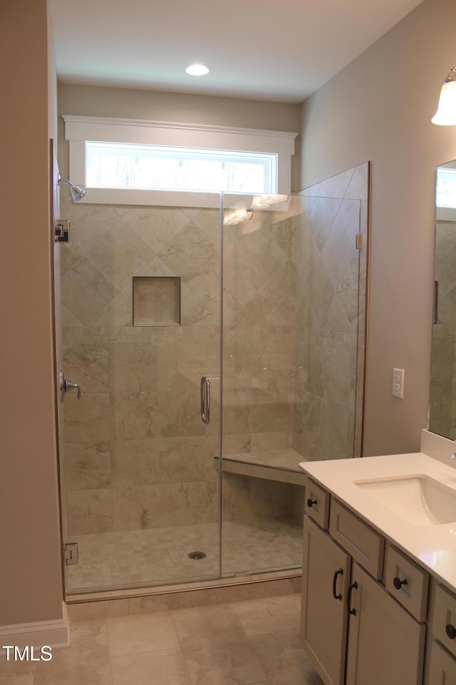 bathroom featuring vanity, plenty of natural light, and a shower with door