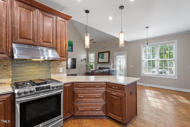 kitchen with gas range, decorative backsplash, kitchen peninsula, and hanging light fixtures