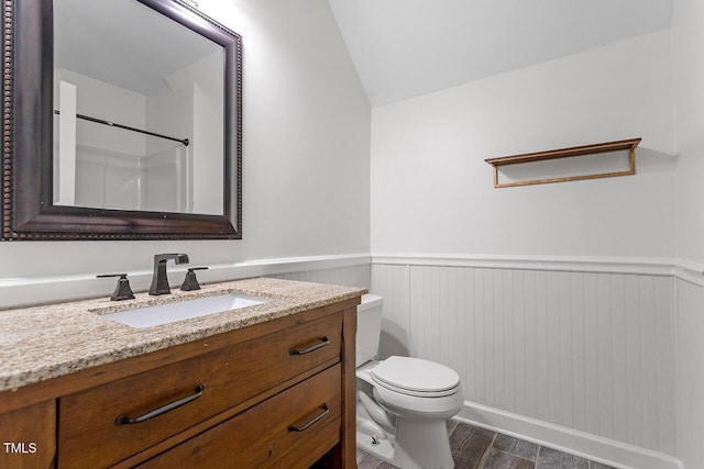 bathroom featuring lofted ceiling, toilet, hardwood / wood-style floors, and vanity