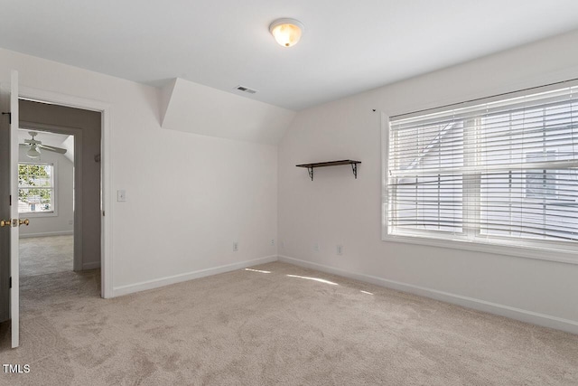 carpeted spare room featuring vaulted ceiling