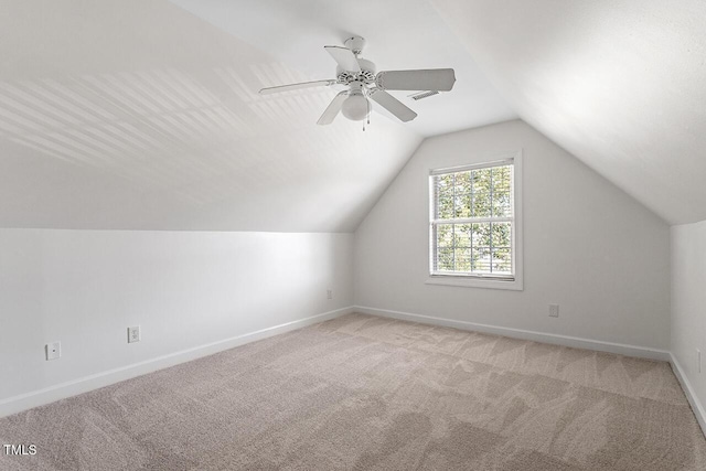 additional living space featuring vaulted ceiling, light colored carpet, and ceiling fan