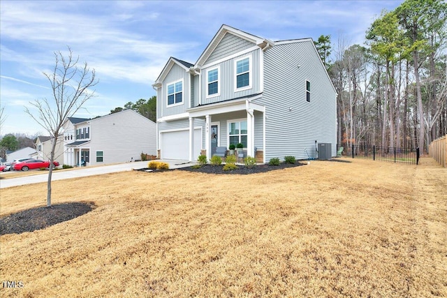 view of front of home featuring a garage, cooling unit, and a front yard