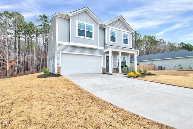 view of front of property featuring a garage, central AC, and a front lawn