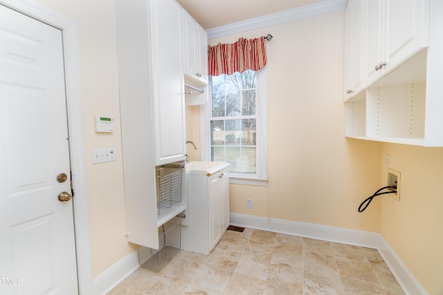 washroom with sink, crown molding, and cabinets