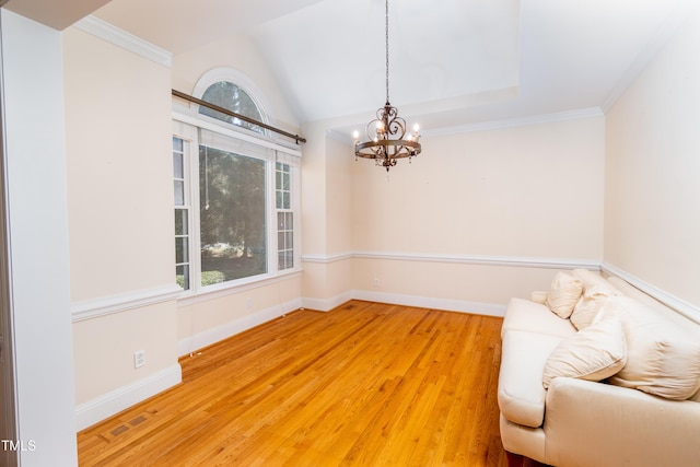 unfurnished room featuring ornamental molding, vaulted ceiling, hardwood / wood-style floors, and a chandelier