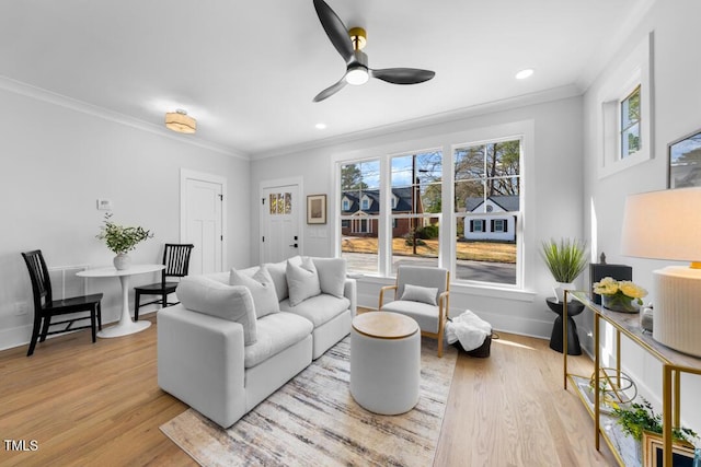 living room featuring crown molding, plenty of natural light, and light hardwood / wood-style floors