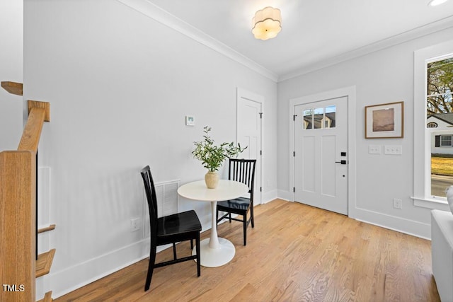 foyer entrance featuring crown molding and light hardwood / wood-style flooring