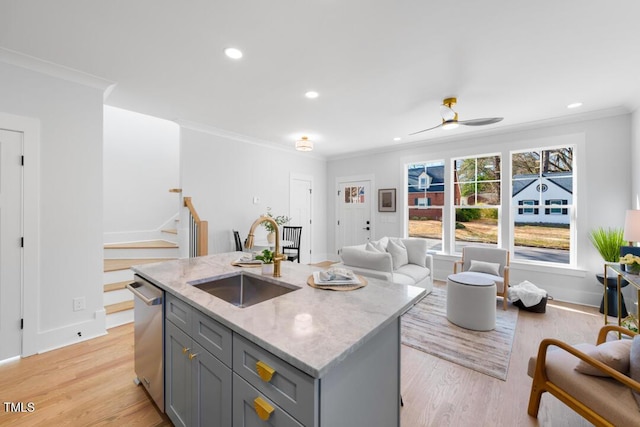 kitchen with sink, gray cabinetry, light stone counters, a center island with sink, and dishwasher