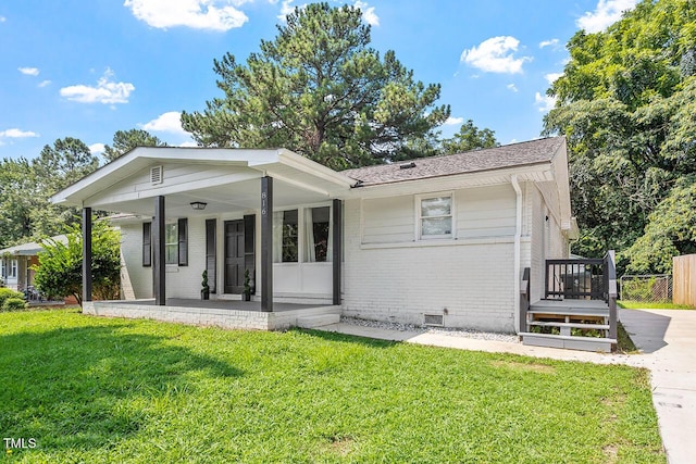 rear view of property featuring a porch and a yard