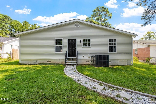 rear view of property featuring a yard and central AC unit