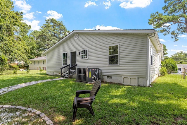 back of house featuring central AC and a lawn