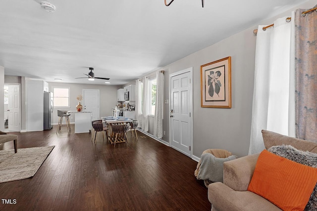 dining space with ceiling fan and dark hardwood / wood-style flooring