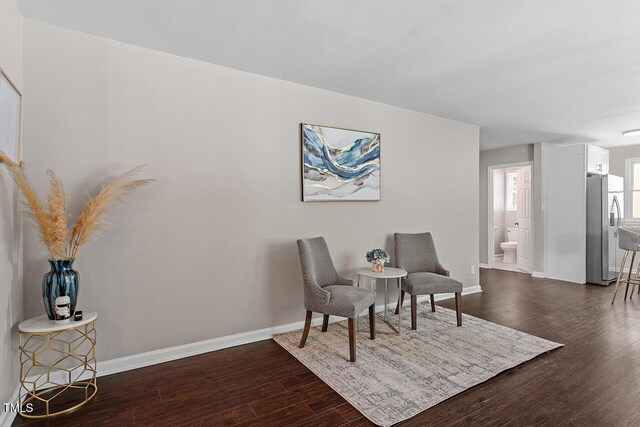 sitting room with dark wood-type flooring