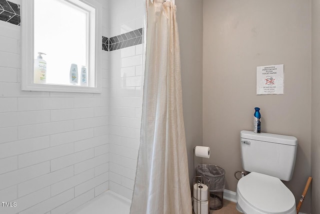 bathroom featuring toilet and curtained shower