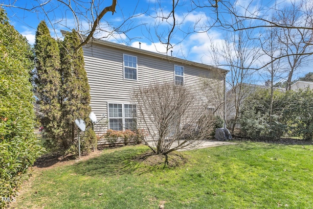 view of side of property with a patio and a yard