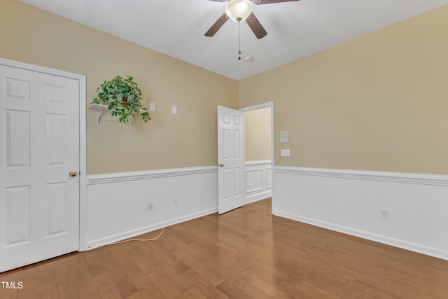 empty room with wood finished floors, baseboards, and ceiling fan