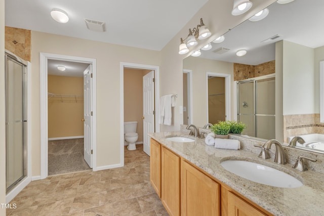 bathroom with visible vents, a stall shower, toilet, and a sink