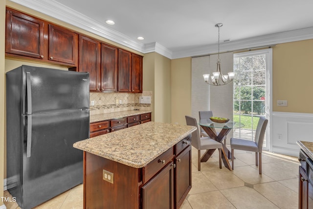 kitchen featuring ornamental molding, tasteful backsplash, freestanding refrigerator, light tile patterned floors, and a chandelier