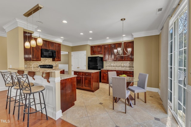 kitchen with visible vents, black appliances, ornamental molding, a peninsula, and dark brown cabinets