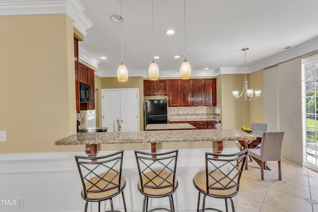 kitchen with backsplash, a peninsula, light tile patterned flooring, a notable chandelier, and black appliances