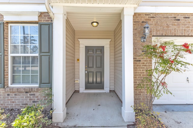 view of exterior entry featuring brick siding