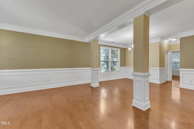 unfurnished room with a wealth of natural light, ornate columns, and hardwood / wood-style floors