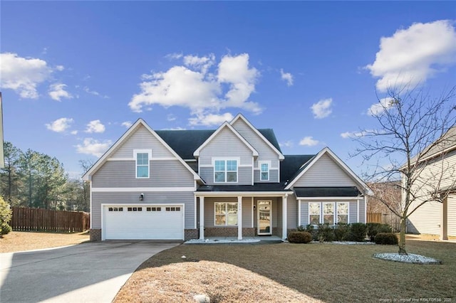 view of front of home with a garage, covered porch, and a front yard